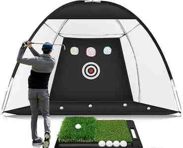 The image shows a golfer practicing with a golf net and target. The golfer is in a stance, preparing to hit the ball toward the target at the center of the net. The setup includes a small artificial grass mat with golf balls, ideal for practicing shots indoors or outdoors.